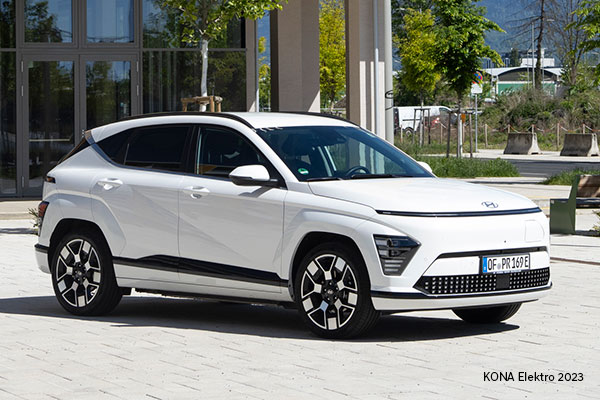 Das Bild ist ein Foto. Es zeigt das Fahrzeugmodell KONA Elektro von dem Autohersteller Hyundai. Das Auto ist weiß.